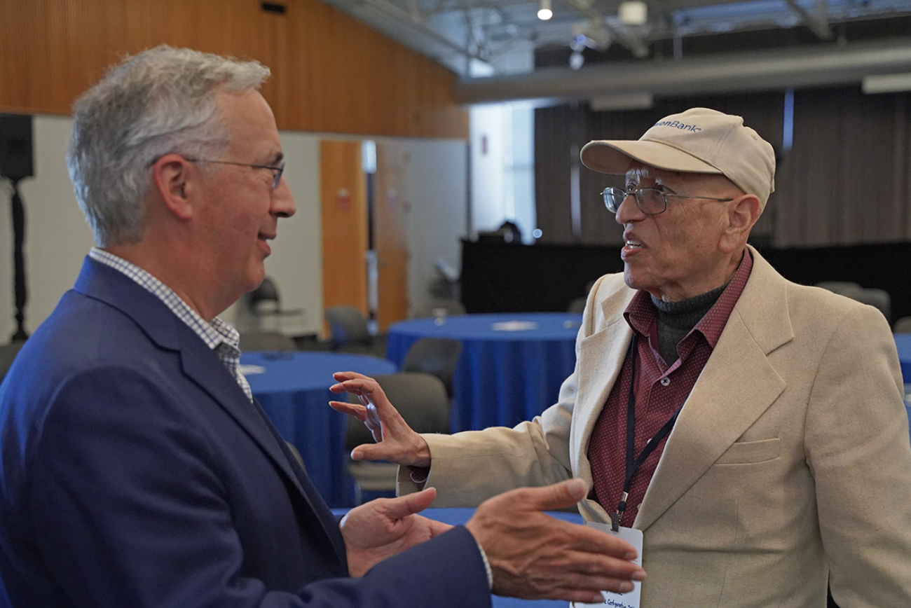 Two male attendees of the Silicon Valley Deal Machine don suits and speak passionately and descriptively. This event, hosted by the Silicon Valley Chapter, brought together over 110 innovation leaders, IP professionals, and business dealmakers at the Computer History Museum in Mountain View, California.